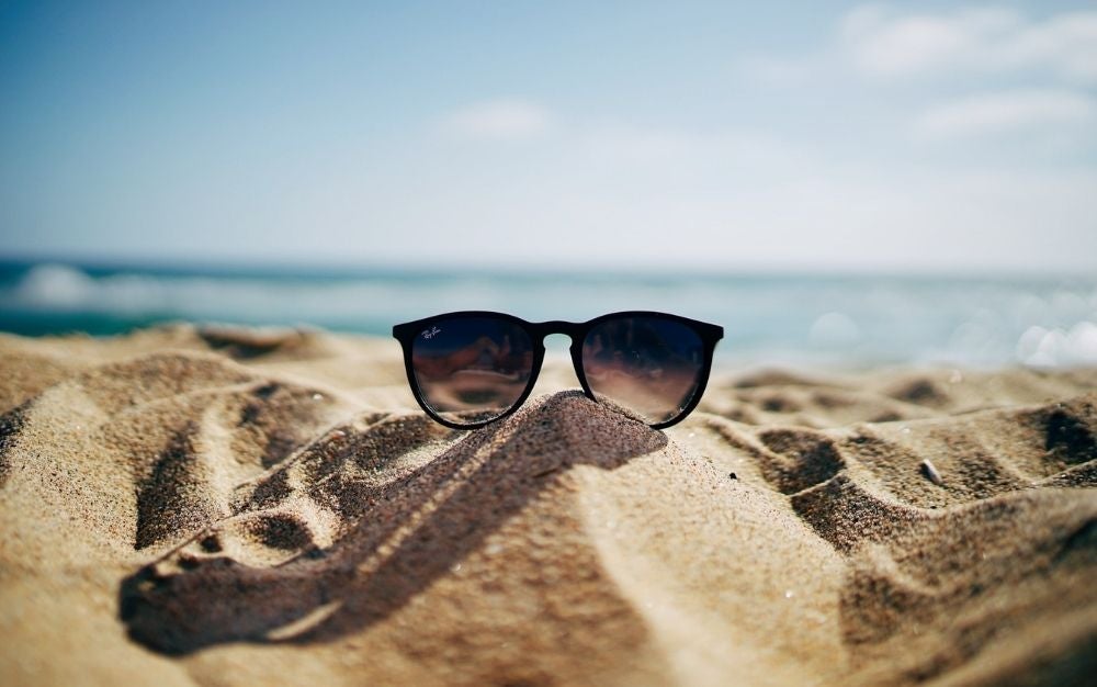 https://www.fieldandstream.com/uploads/2021/05/27/A-pair-of-sunglasses-on-the-beach..jpg?auto=webp