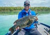 YouTube angler Ben Nowak in a boat, holding a big smallmouth bass.