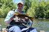 Angler in kayak holding fish caught with Shimano FX Spinning Combo