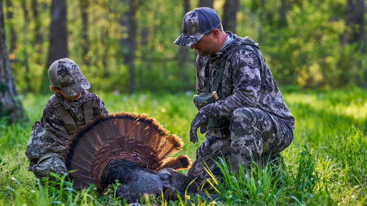 Father and son turkey hunting in the woods