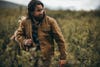 Man walking through field in Filson tin cloth jacket