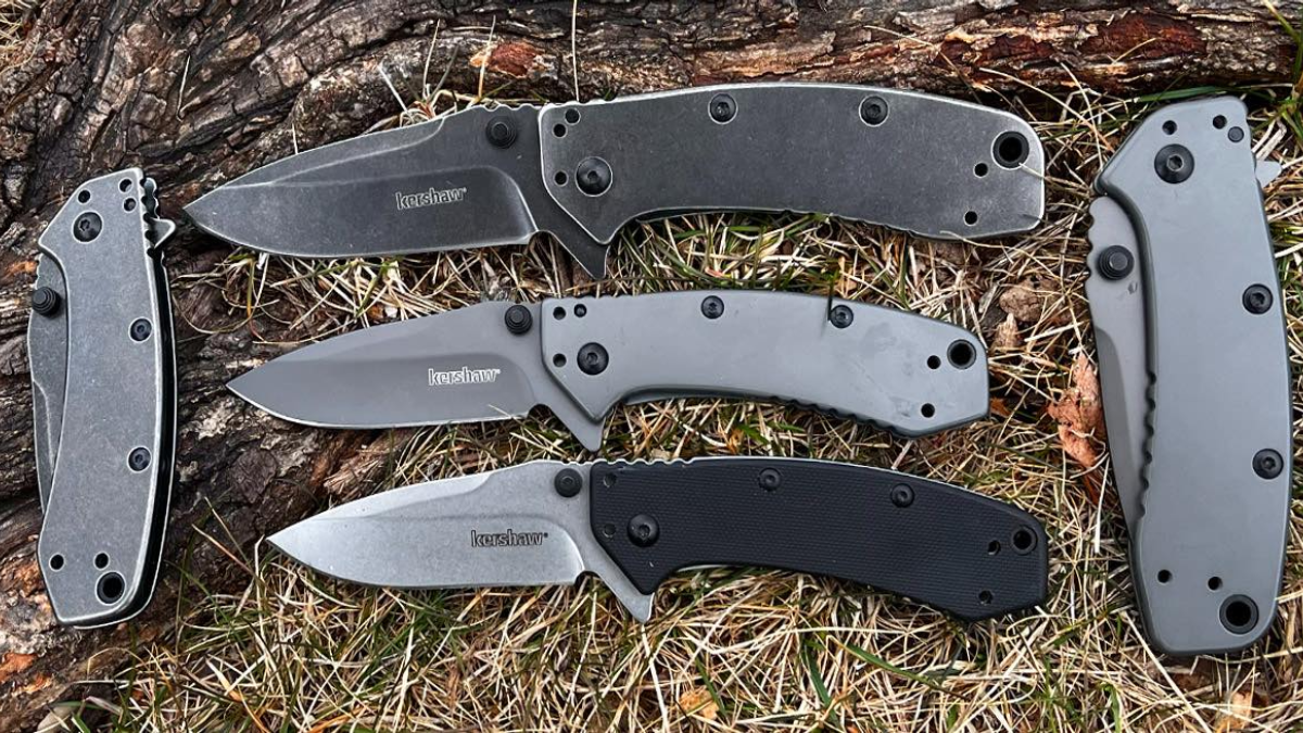 Assorted Kershaw folding knives laying on grass