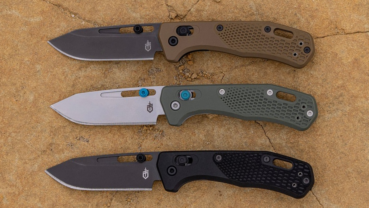 Trio of Gerber Gear folding pocket knives on wood table