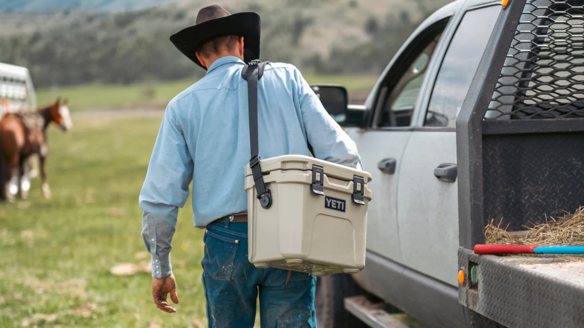 Rancher carrying tan Yeti Roadie 15 hard cooler