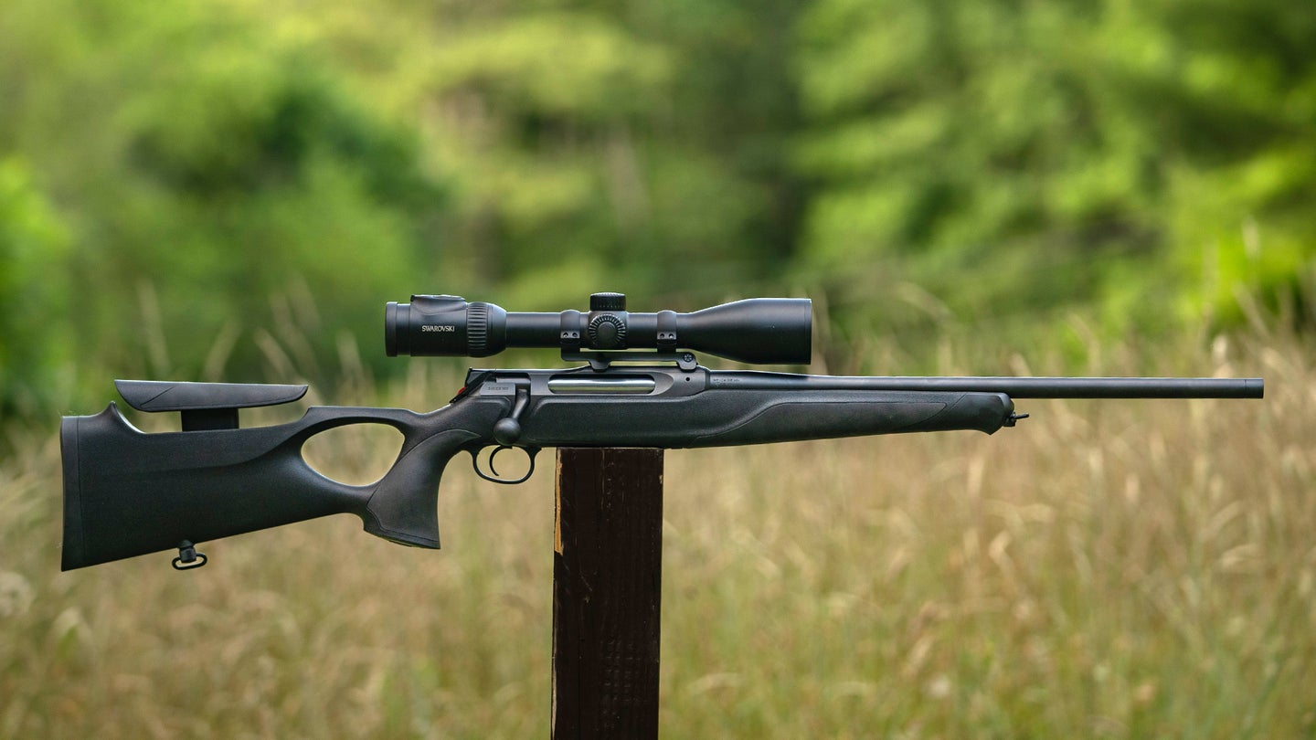 The new Sauer 505 Synchro XT bolt-action rifle balanced on a post in a field.