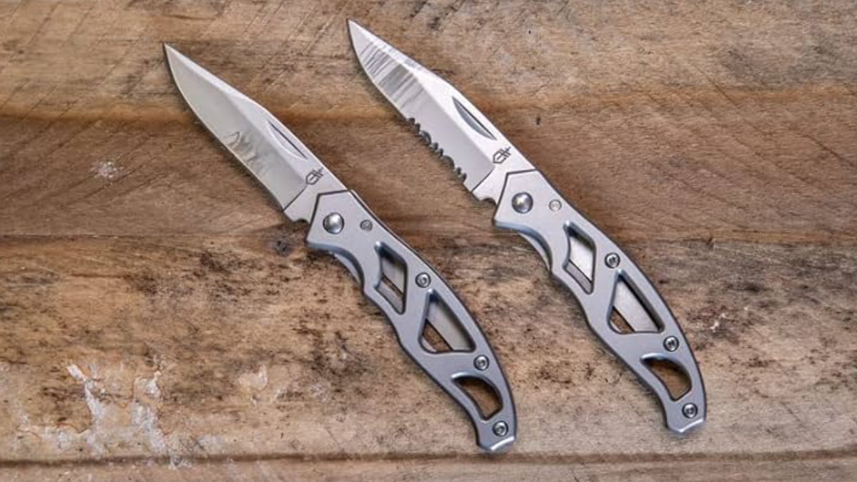 Two Gerber Paraframe Mini knives sitting on wood table