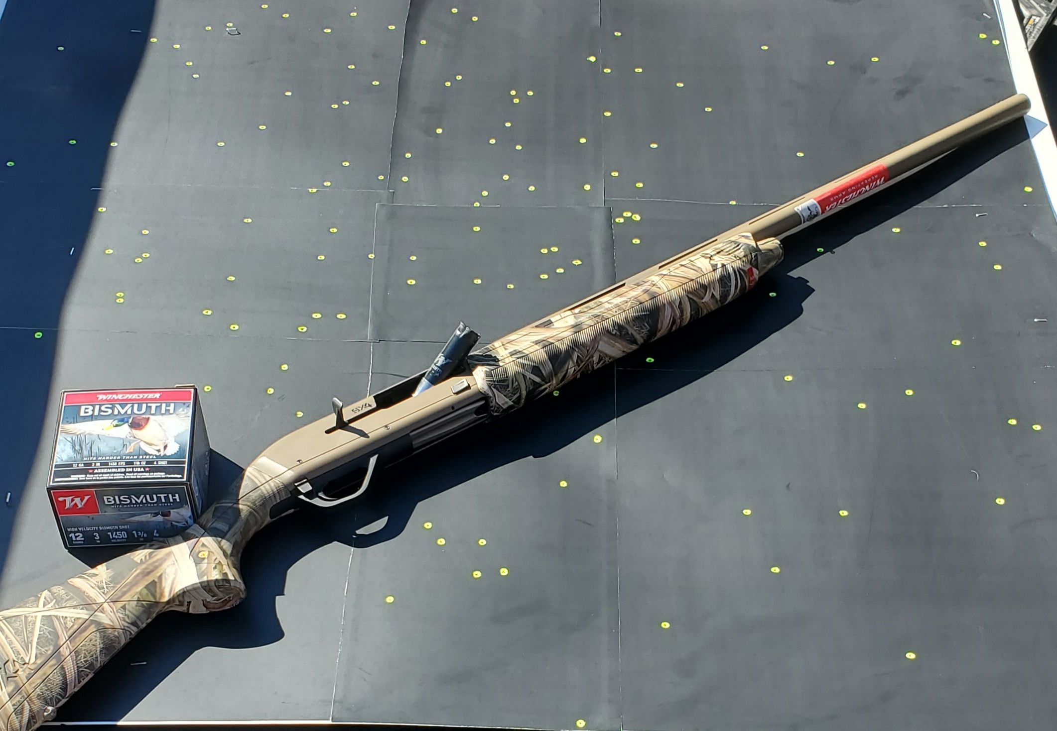 A shotgun and shell on a patterning board. 