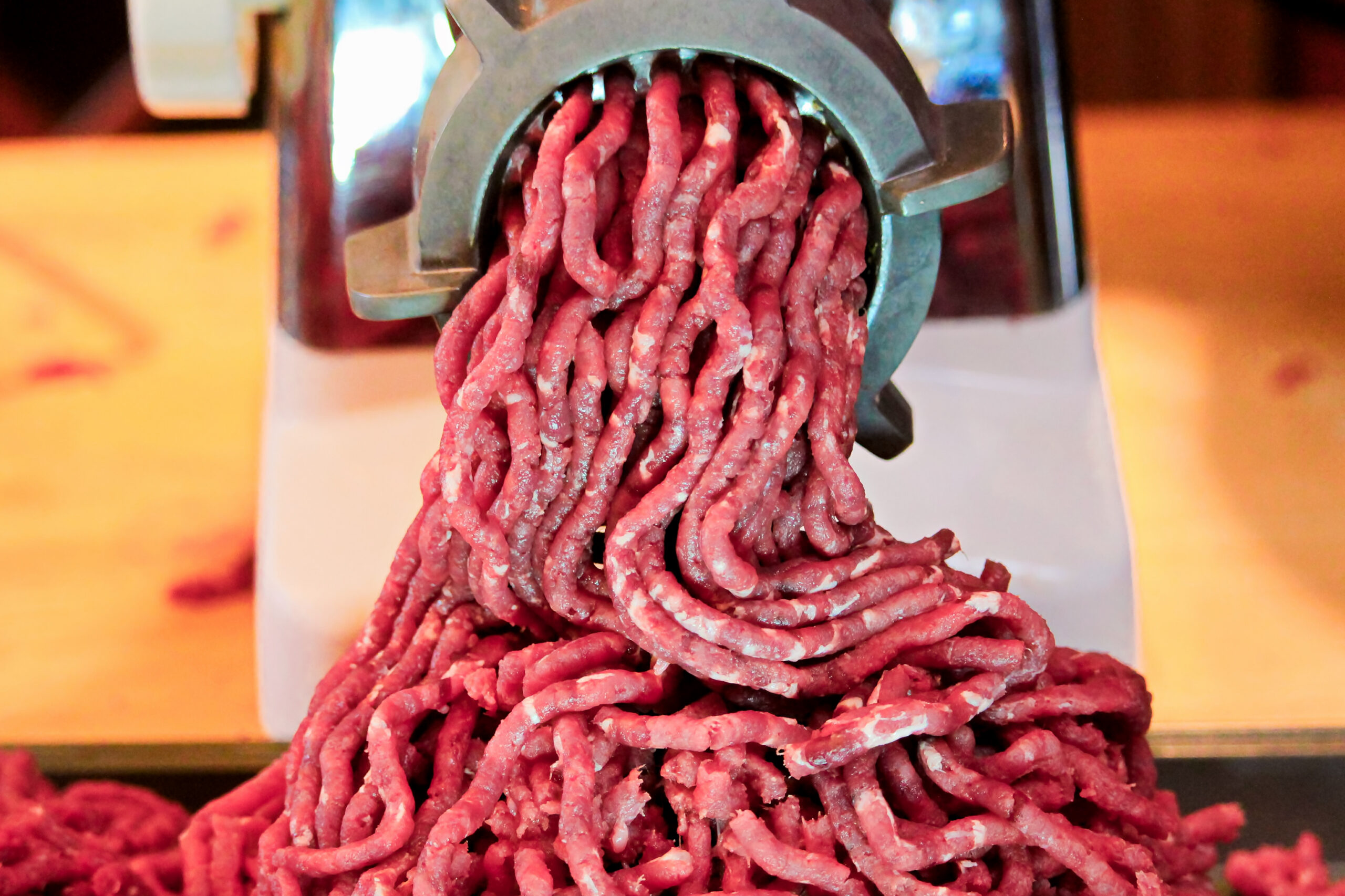 Venison burger coming out of a meat grinder. 