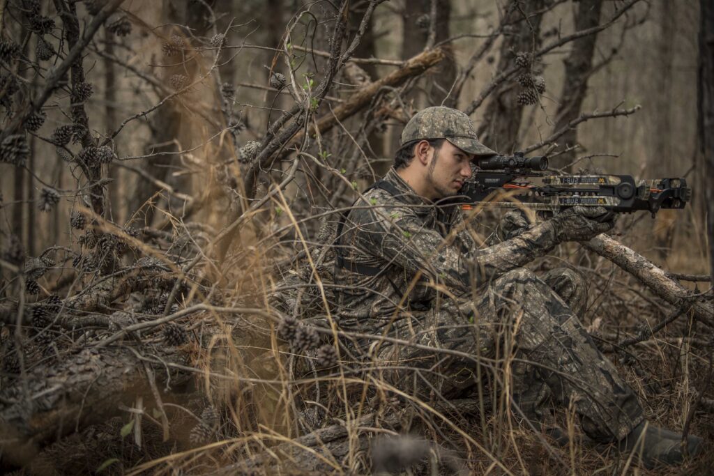 A hunter shoots a crossbow from a ground blind