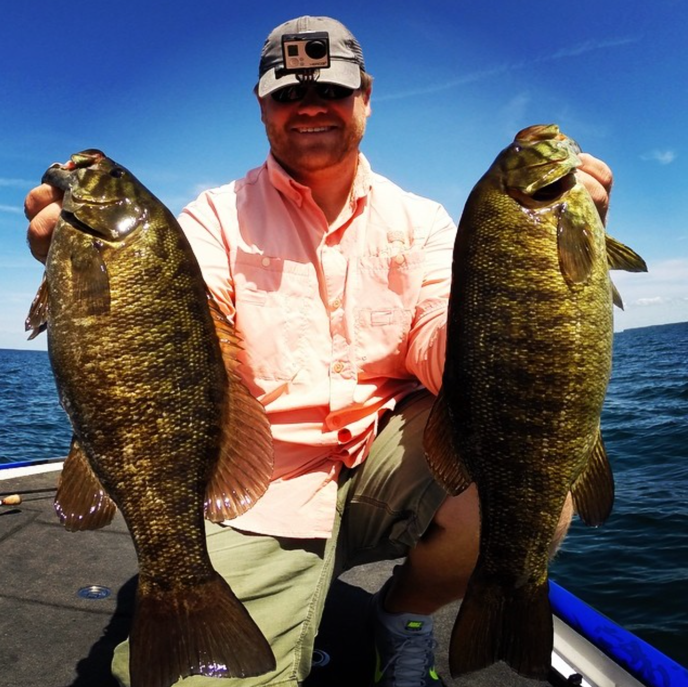 An angler holding two big small mouth bass.