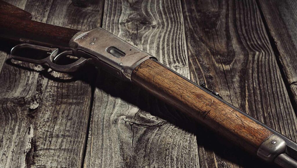 Winchester Model 1894 lying on weatered boards.
