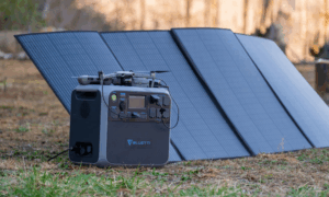 Bluetti portable power station with solar panel and drone outdoors on grass