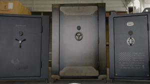 Three Browning gun safes displayed in warehouse, center safe door open showing interior