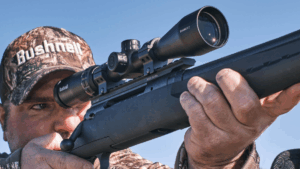 Hunter aiming rifle with Bushnell Banner 2 scope wearing camouflage gear outdoors