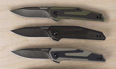 Three Kershaw folding pocket knives in green, black, and gray on wood surface