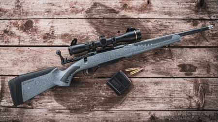 The 40 Best Cyber Monday Gun Deals of 2024 Bolt-action rifle with scope and ammunition on rustic wooden surface
