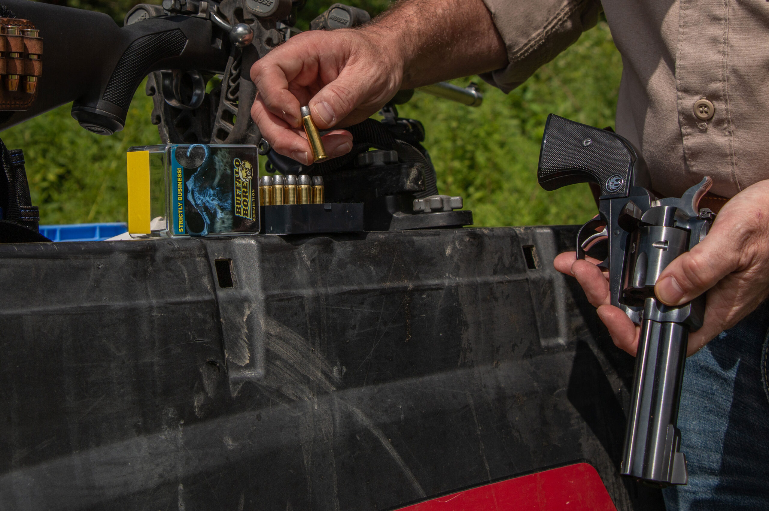 A shooter loads a revolver.