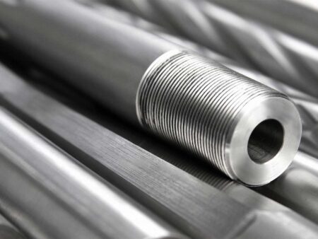 Threaded metal pipe nipple resting on polished stainless steel rods