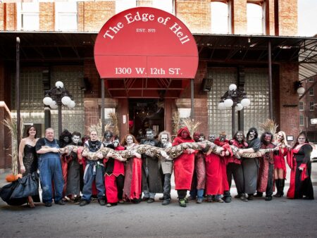 Costumed performers holding giant snake outside Edge of Hell haunted house Kansas City