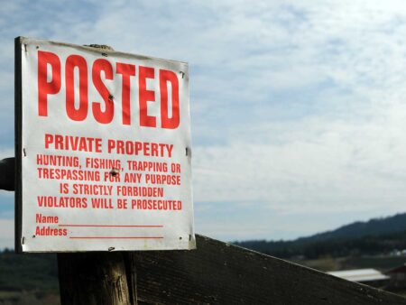 Posted private property sign warning against hunting, fishing, trapping, and trespassing.