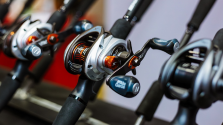 Row of Abu Garcia baitcasting fishing reels mounted on black rods display