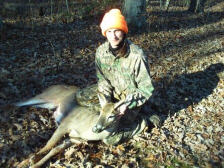 Thanks, Dad: Hunting Without Daddy Hunter in camouflage and orange cap posing with harvested whitetail deer outdoors.