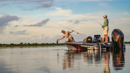 Get Up to 51% Off Fishing Gear at the Bass Pro Labor Day Sale Two anglers fishing from a Nitro Z20 bass boat on calm water at sunset.