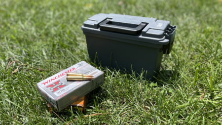 Winchester Super-X 308 ammunition box with bullets beside a green plastic ammo can