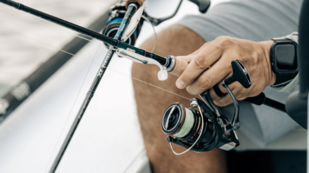 The 6 Best Spinning Reels Person holding fishing rod with spinning reel loaded with braided line on boat