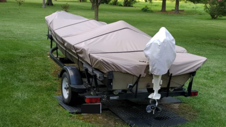 The Best Boat Covers on Amazon Covered jon boat with outboard motor on trailer parked on green lawn