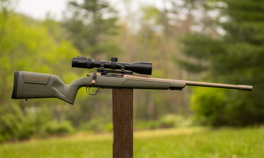 Christensen Evoke rifle balanced on a post in a field.
