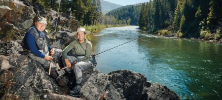 The Allies: How Two Businessmen Have Joined Forces to Fight for Public Lands Two men fly fishing on rocky riverbank surrounded by mountain forest landscape.