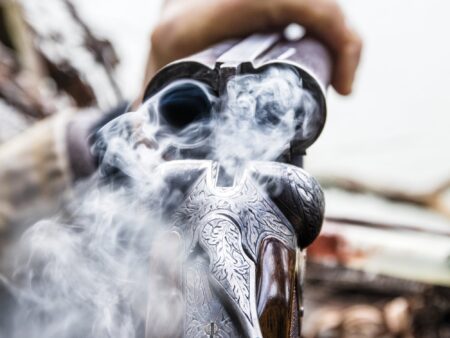 F&S Classics: Bo Whoop Comes Home Ornate engraved double-barrel shotgun smoking after firing held by hunter outdoors