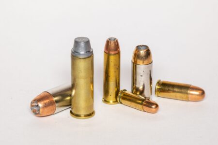 Six assorted pistol and revolver ammunition cartridges displayed on white background.