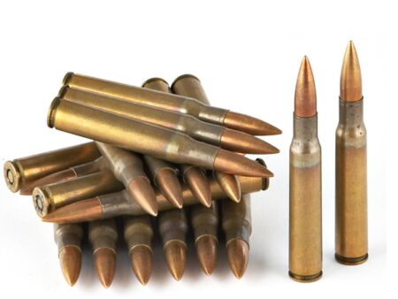 Collection of rifle ammunition cartridges with brass casings and copper-tipped bullets on white background