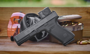 Glock 21 Gen5 45 Auto pistol with red dot sight on wooden surface