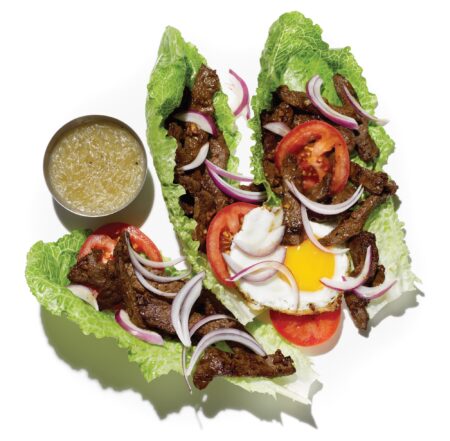 Lettuce wraps filled with grilled beef, fried egg, tomato, red onion, and dipping sauce.