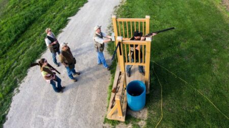 How to Shoot Trap, Skeet, and Sporting Clays Aerial view of people at an outdoor shooting range with elevated platform