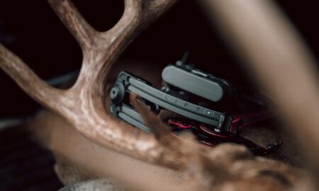 LIFT multi-tool displayed among deer antlers with red wiring accessories visible