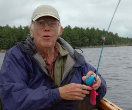 F&S Classics: Fishing With Barbie Elderly man fishing on a lake holding a colorful toy fishing rod outdoors
