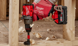 Milwaukee Fuel M18 cordless drill boring into wood floor at construction site
