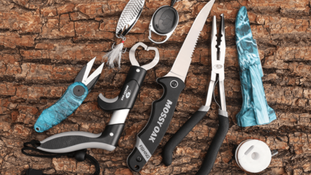 This 4-Piece Fishing Tool Kit Is On Sale for Just $25 Right Now Mossy Oak fishing tools set including knife, pliers, lures, and accessories on wood