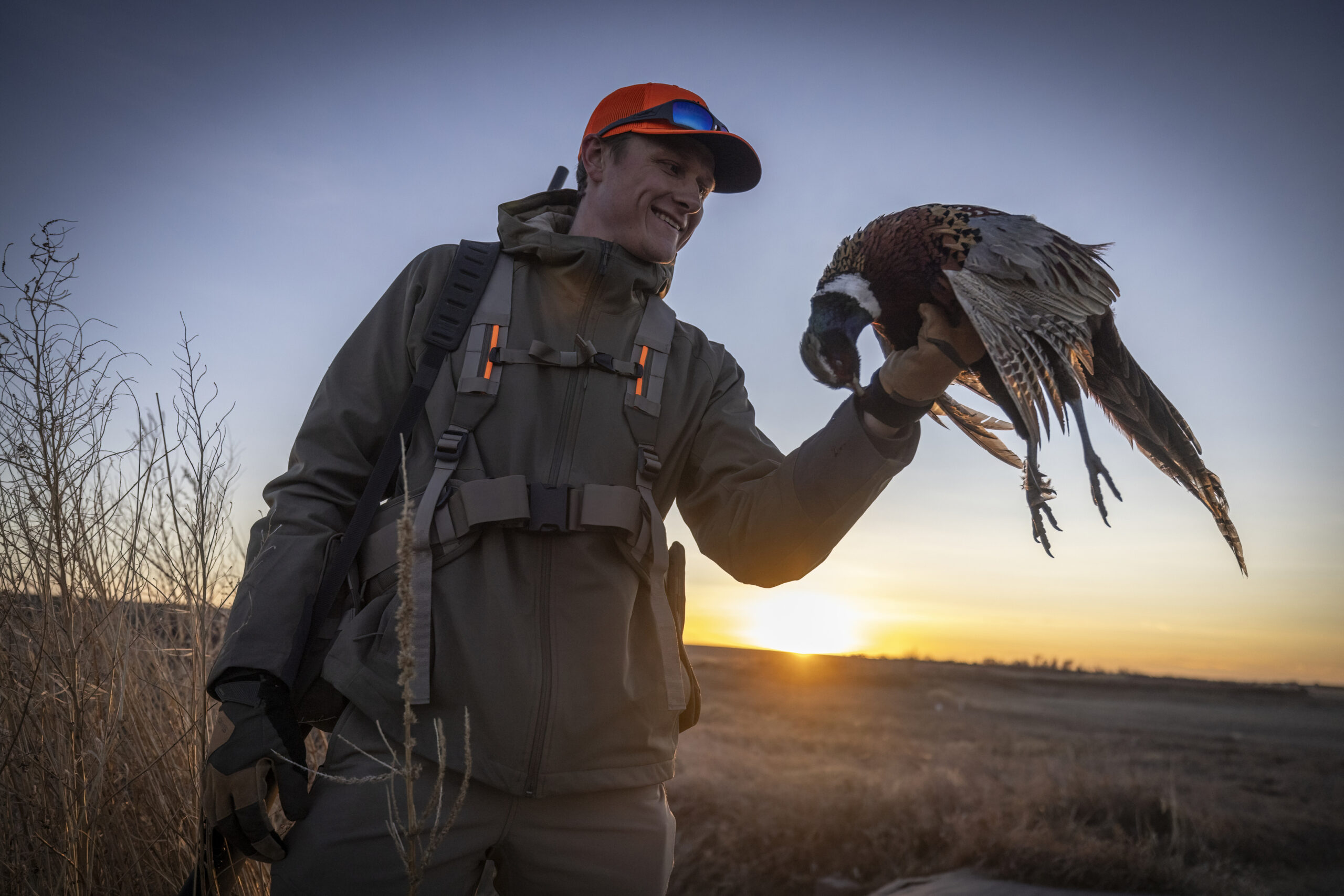 hunter holds up pheasant