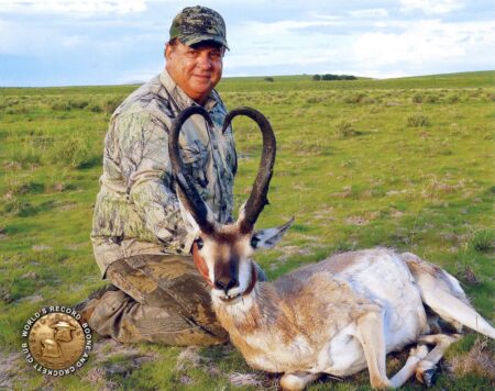It’s Official: New World-Record Antelope from New Mexico Hunter poses with harvested pronghorn antelope on open grassland, Boone and Crockett Club record