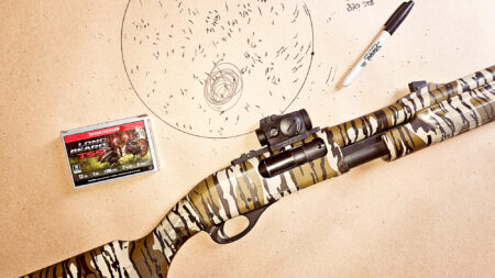Camouflage shotgun with Winchester Long Beard turkey shells and patterned target sheet.