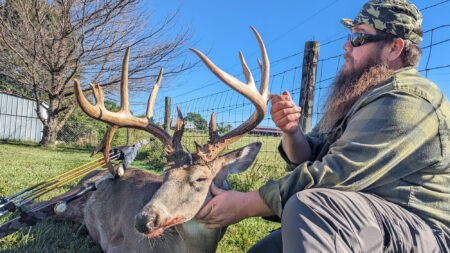 Kentucky Hunter Arrows State Record Trad-Bow Buck Hunter in camo posing with large trophy whitetail buck after successful hunt.
