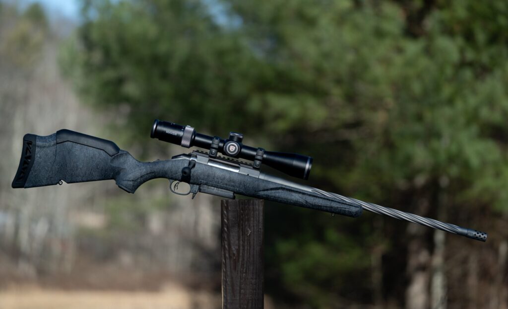 Ruger American Gen 2 rifle balanced on a post in a field.