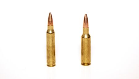 224 Valkyrie vs 223 Remington Two brass rifle cartridges with copper-tipped bullets on white background