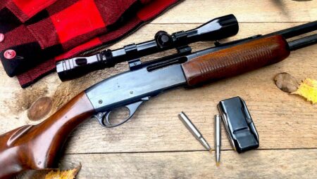 Remington semi-automatic hunting rifle with scope, ammunition, and magazine on wooden surface.