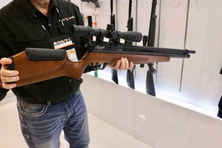 Best Air Guns of 2024 Man holding Benjamin Marauder PCP air rifle with scope at trade show display